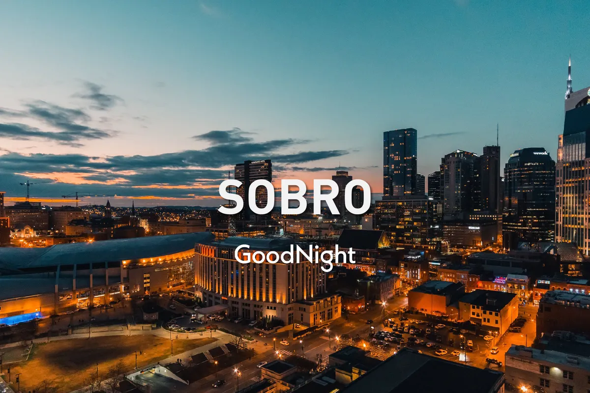 A panoramic view of the Nashville city skyline at sunset, with illuminated buildings and a dynamic city atmosphere. The image radiates warmth and excitement, suggesting the onset of a lively night filled with concerts, rooftop gatherings, and memorable group outings.