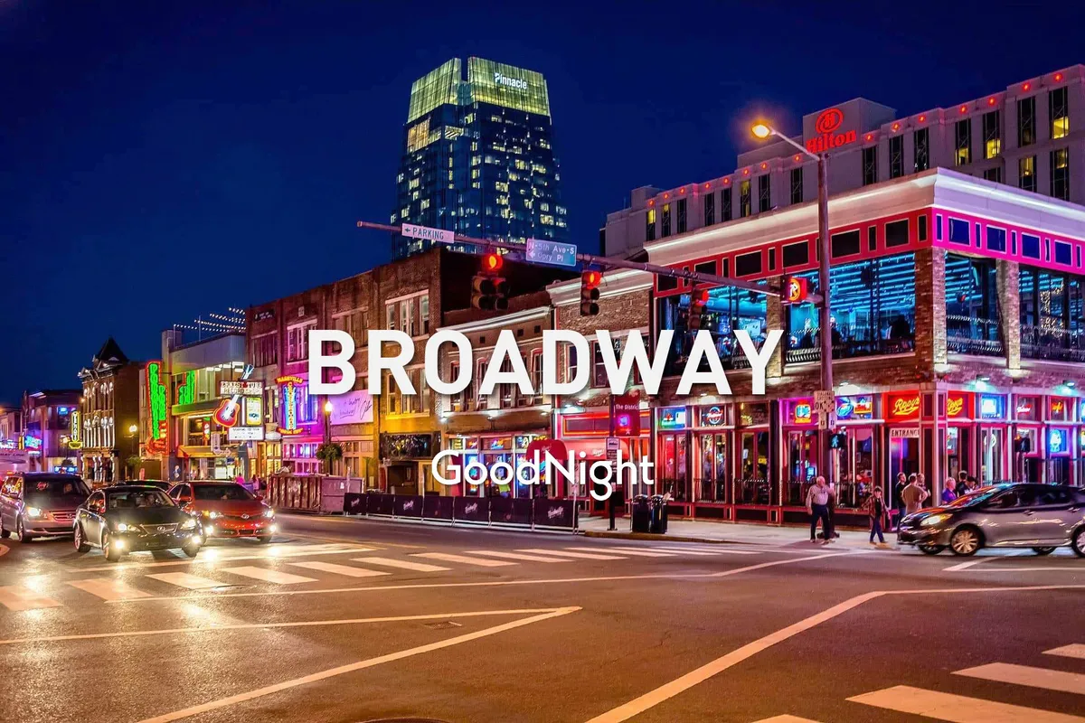 A vibrant street scene at night featuring bright neon signs, a bustling crowd of people walking along the sidewalks, and the lively activity of nightlife and entertainment venues. The image captures the unmistakable energy and iconic atmosphere of downtown Nashville, inviting visitors to experience its famed music and nightlife culture.