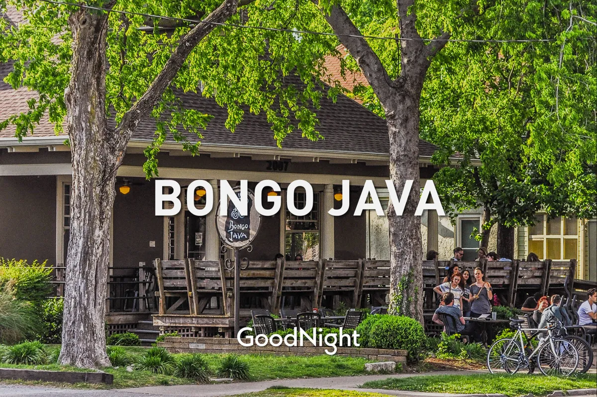 This image captures the exterior of Bongo Java, a beloved local coffee shop in East Nashville. People are seated outside, bicycles are parked nearby, and green trees frame the scene, establishing a lively, community-oriented atmosphere.